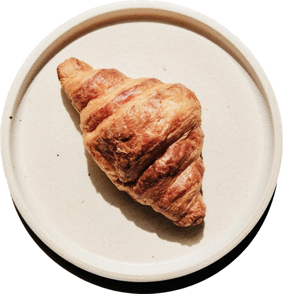 Чашка кофе и круассан на тарелке